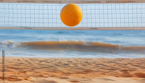 Yellow volleyball ball flying in the air on the court on the sand beach with the volleyball net. Sea or ocean waves behind, summer travel holiday leisure activity

