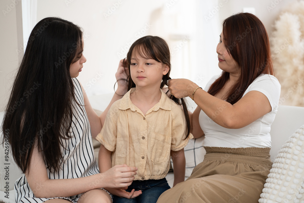 Mother with daughter take care little daughter and tied her hair at home Mother with daughter take care little daughter and tied her hair at home