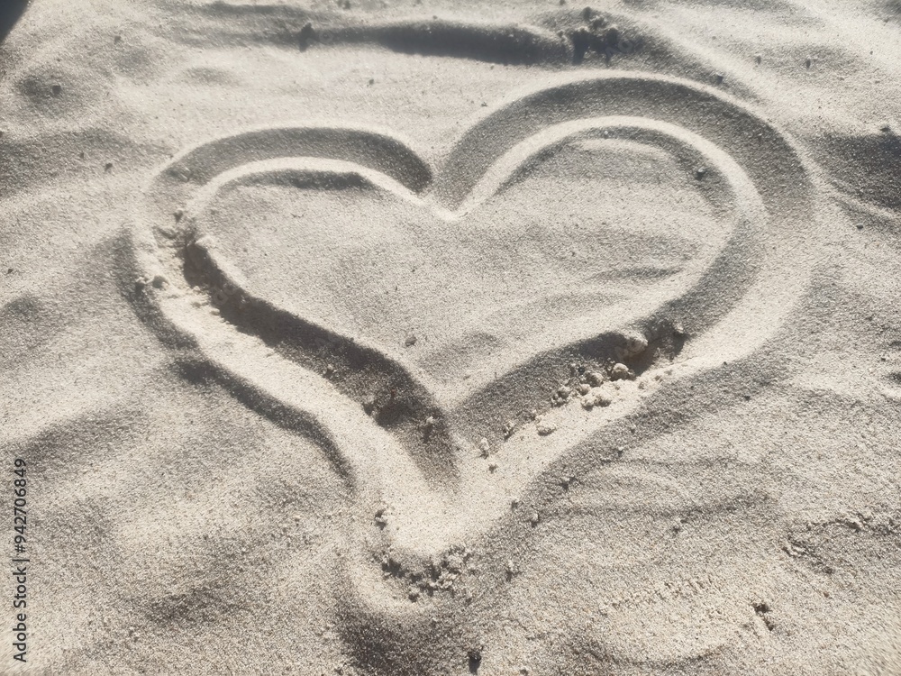 Obraz premium Love message drawn in the sand in the shape of a heart. Heart imprint in the sand. Heart drawn in the sand.