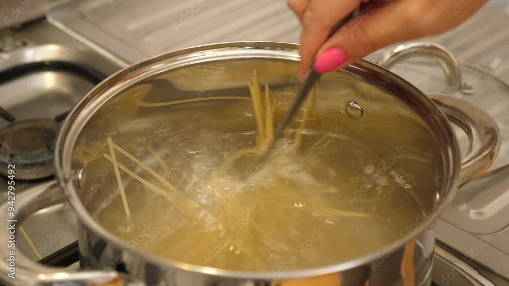 Spaghetti is cooked in a pan with frequent stirring. Spaghetti is cooked in a pan with frequent stirring.