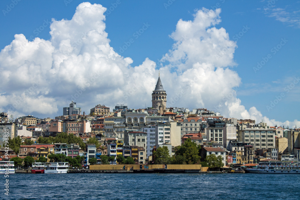 Istanbul, Turkey - August 10, 2024: Panoramic view of Galata Tower and ancient architecture in the historic part of the city on the shores of the Sea of Marmara and tourist boats on a sunny summer Istanbul, Turkey - August 10, 2024: Panoramic view of Galata Tower and ancient architecture in the historic part of the city on the shores of the Sea of Marmara and tourist boats on a sunny summer