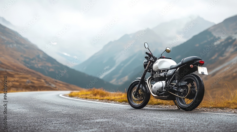 A sleek motorcycle parked on a winding road with stunning mountain scenery in the background, perfect for adventure enthusiasts. A sleek motorcycle parked on a winding road with stunning mountain scenery in the background, perfect for adventure enthusiasts.