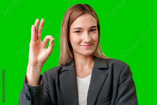 Young Businesswoman Making Okay Gesture Against Green Screen