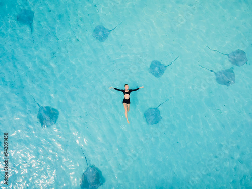 фотографія Woman swims in sea with stingrays in Maldives