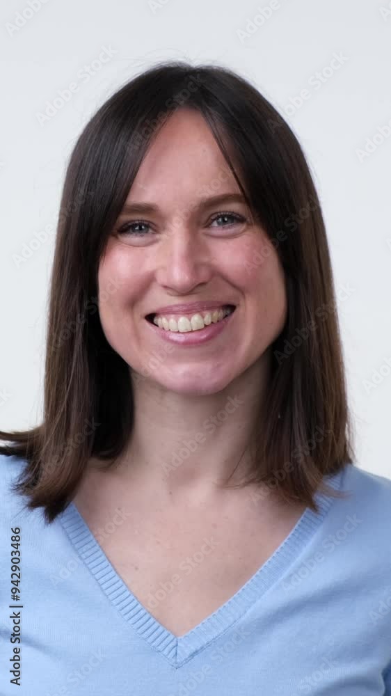 Close up portrait of a smiling and optimistic middle aged Caucasian woman, standing on white background. Concept of a happy and positive people. Vertical video. Close up portrait of a smiling and optimistic middle aged Caucasian woman, standing on white background. Concept of a happy and positive people. Vertical video.