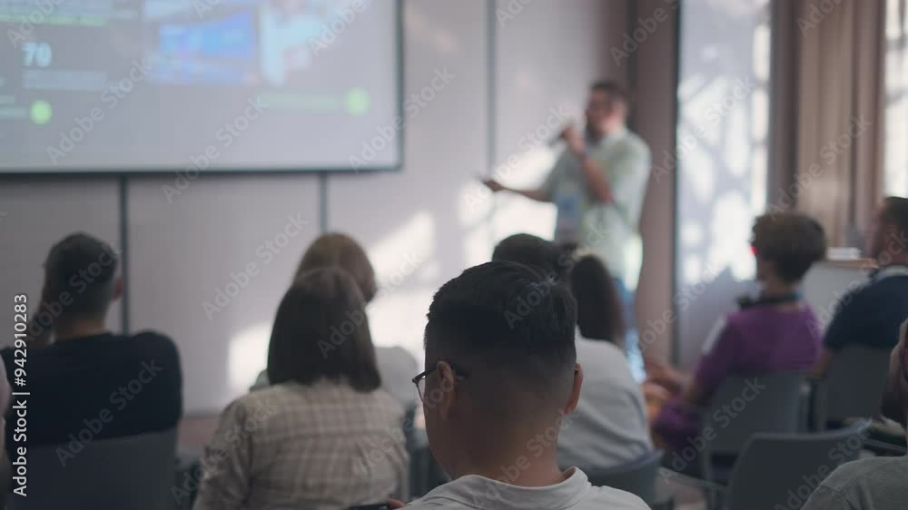 Speaker presents to an attentive audience in a contemporary conference room. The image captures the learning atmosphere and engagement of participants during a business presentation. Speaker presents to an attentive audience in a contemporary conference room. The image captures the learning atmosphere and engagement of participants during a business presentation.