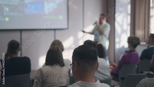 Wallpaper Mural Speaker presents to an attentive audience in a contemporary conference room. The image captures the learning atmosphere and engagement of participants during a business presentation. Torontodigital.ca