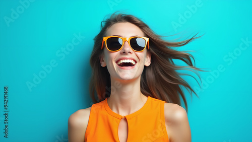 Wallpaper Mural A joyful young woman wearing a bright orange dress and sunglasses smiles widely against a vibrant blue background Torontodigital.ca