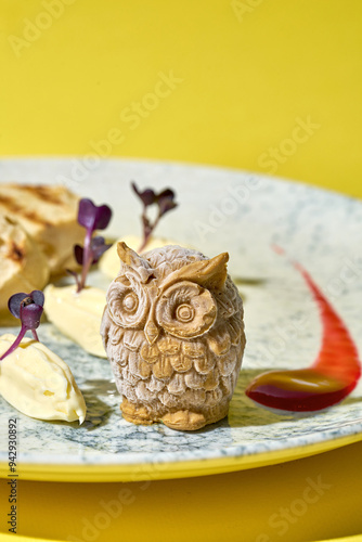 artistic presentation of pate shaped into adorable owls. Served on a plate with toasted bread and garnished with fresh herbs