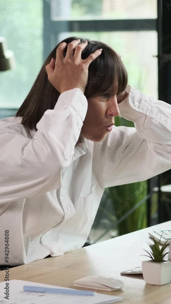 Caucasian middle aged businesswoman upset and surprised by failure while working in the office. Concept of a work problems and troubles. Vertical video.