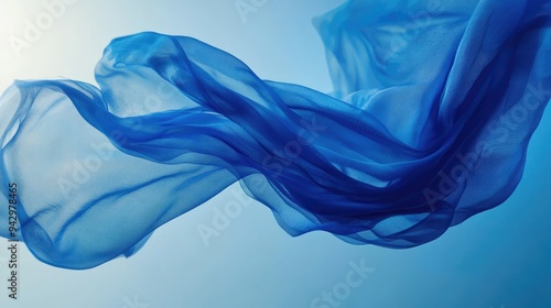 Blue fabric swirling gracefully in mid-air, creating a sense of movement and fluidity