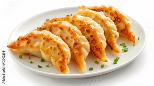 A plate of dumplings with green onions on top. The dumplings are golden brown and look delicious