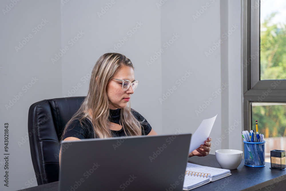 Hispanic lawyer reviewing documents in an office setting