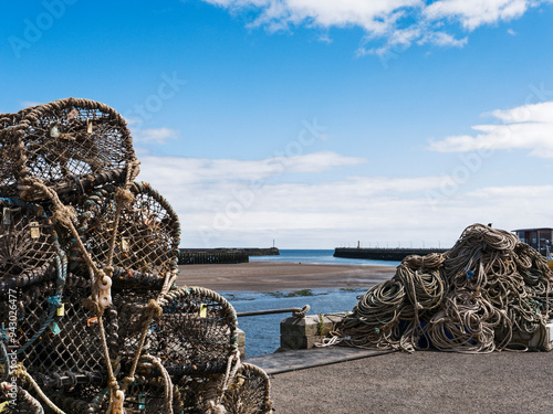 Amble harbour, Northumberland, UK with lobster pots and piers at low tide. photo