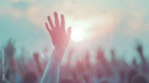 A hand is raised in the air in front of a crowd of people. Concept of unity and togetherness, as the people are all gathered together to celebrate or support a common cause