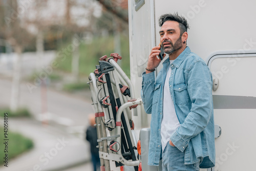 attractive traveler man with caravan and mobile phone