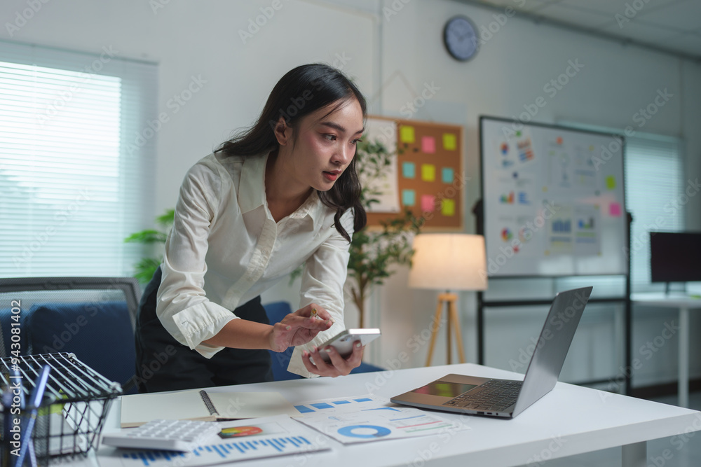 Attractive Asian businesswoman sitting on laptop computer in office Preparing reports, calculating document balance, checking financial documents, making payments happily in the office. Attractive Asian businesswoman sitting on laptop computer in office Preparing reports, calculating document balance, checking financial documents, making payments happily in the office.