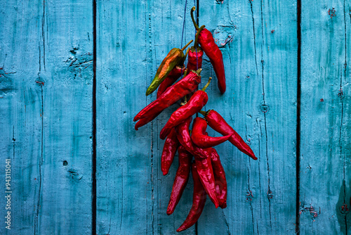 Color horizontal photo, a bunch of red pounding hot chili peppers on a background of a blue wooden door.