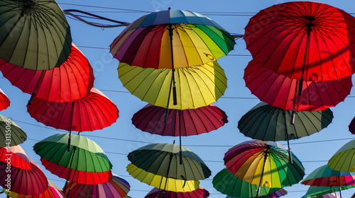 Obraz na płótnie A row of colorful bright umbrellas an alley of shops in Adler (Sochi). w salonie