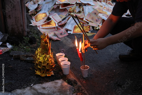Chinese hungry ghost festival prayer offering joss paper money candle burning fire flame smoke