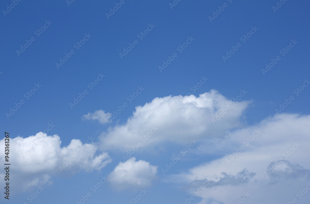 Fototapeta premium A blue sky with puffy clouds.