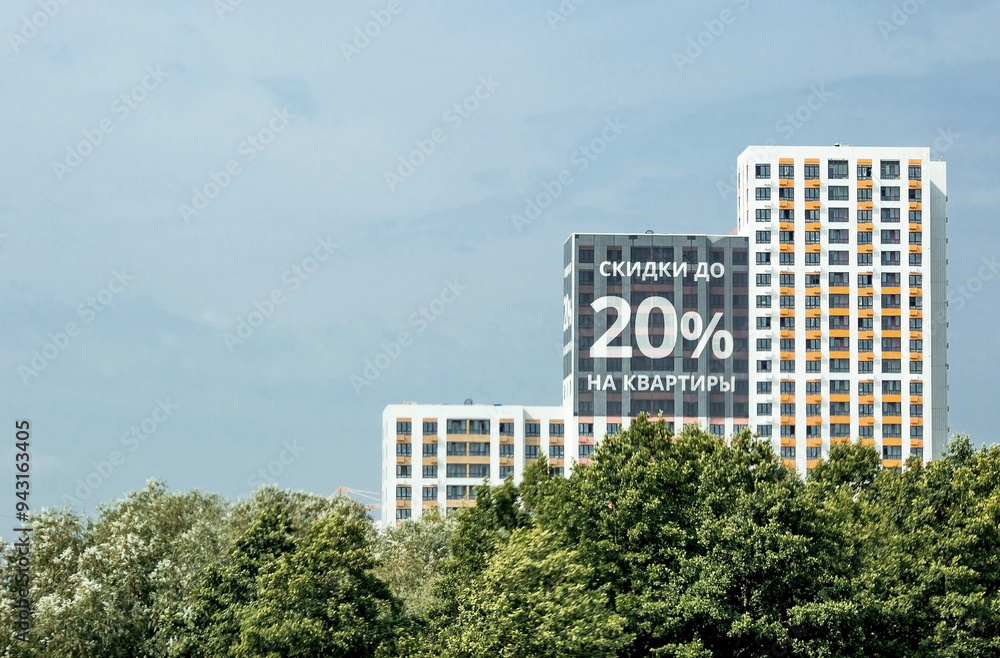 Fototapeta premium Inscription in Russian: 20% discount on apartments. Construction of residential areas. New buildings. Discounts and promotions for apartments. Low purchasing power.