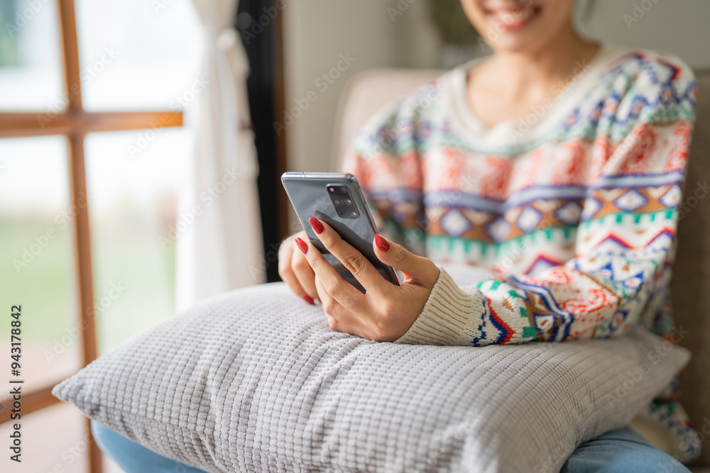 Happy young woman using smartphone mobile addict spending time in front of Christmas tree at home celebrating new year and Christmas Happy young woman using smartphone mobile addict spending time in front of Christmas tree at home celebrating new year and Christmas