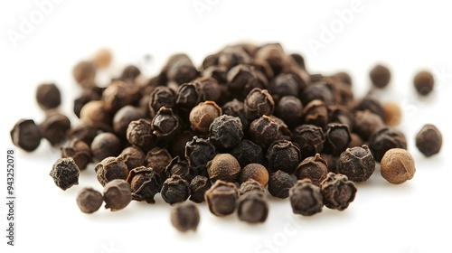 Black peppercorns on a white background ready for cooking with. A close-up view.