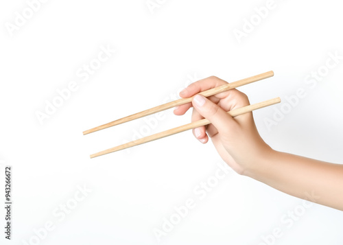 Фотография hand holding wooden chopsticks on white background