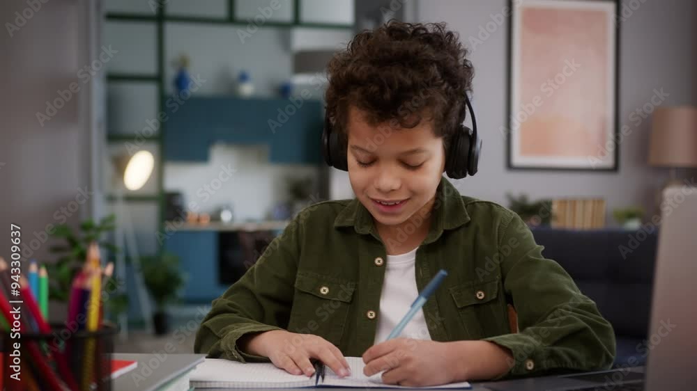 African American little son boy kid child schoolboy pupil wearing headphones earphones listening music audio song dancing writing homework write task study learning studying laptop at home education African American little son boy kid child schoolboy pupil wearing headphones earphones listening music audio song dancing writing homework write task study learning studying laptop at home education