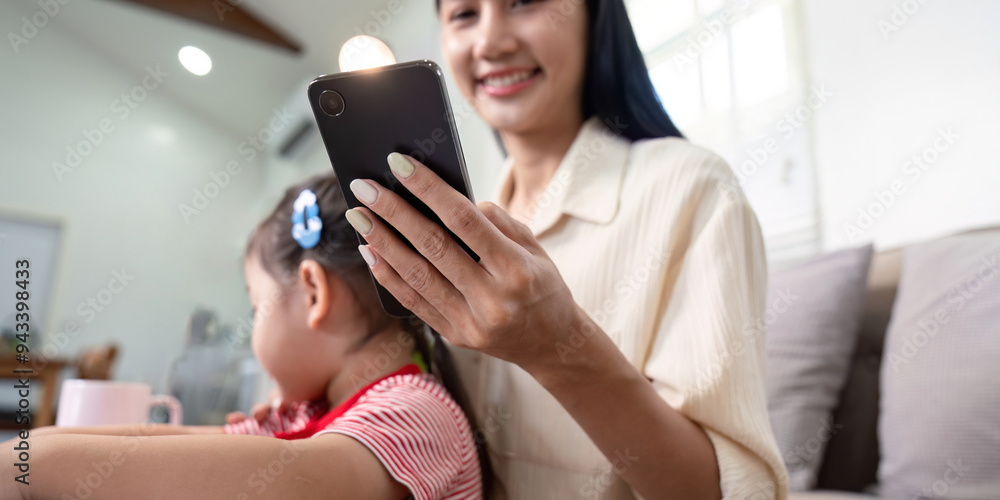 Smiling Mother Using Smartphone with Child Beside Smiling Mother Using Smartphone with Child Beside