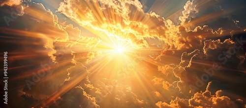 Stunning crepuscular rays or God rays emanate dramatically through a golden sunset sky ideal for a copy space image