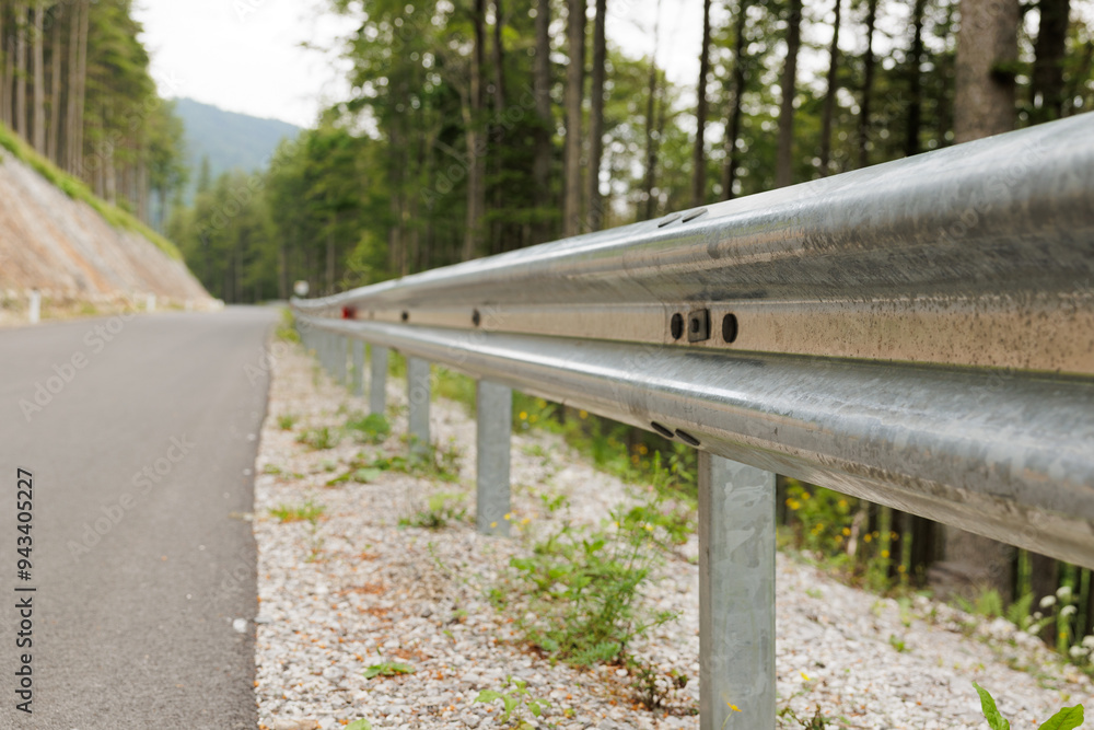 vista ampia, da vicino, di un guardrail che si estende in prospettiva lungo una strada asfaltata di montagna, di giorno, in estate vista ampia, da vicino, di un guardrail che si estende in prospettiva lungo una strada asfaltata di montagna, di giorno, in estate
