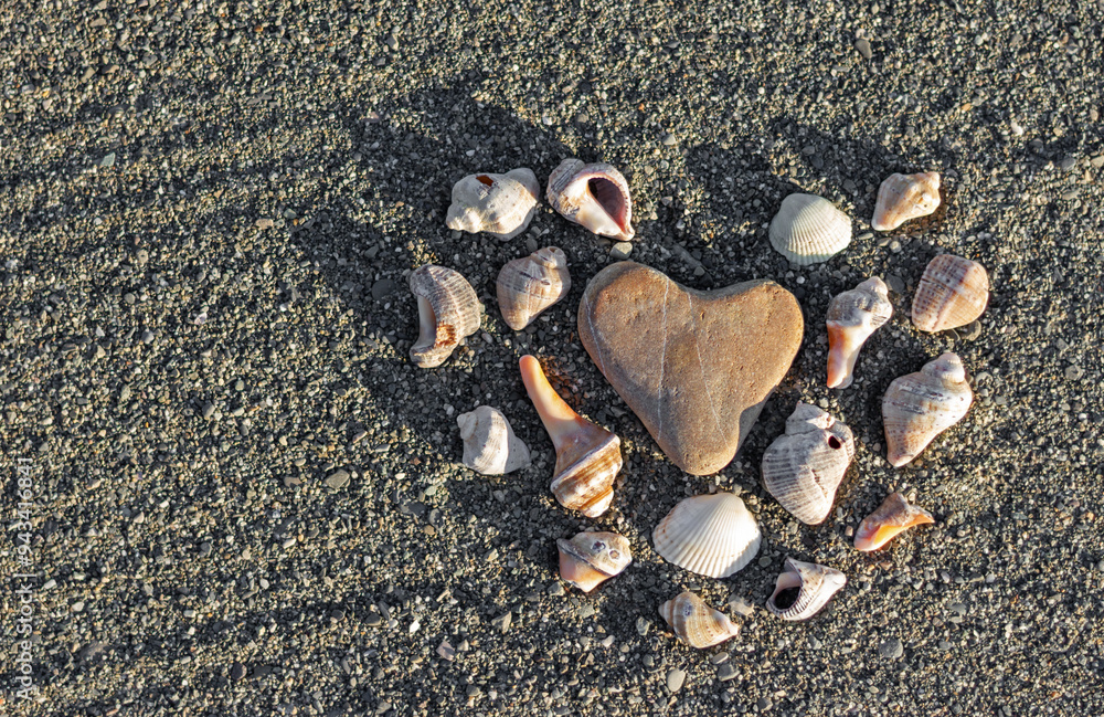 Heart shape made of shells on sea sand