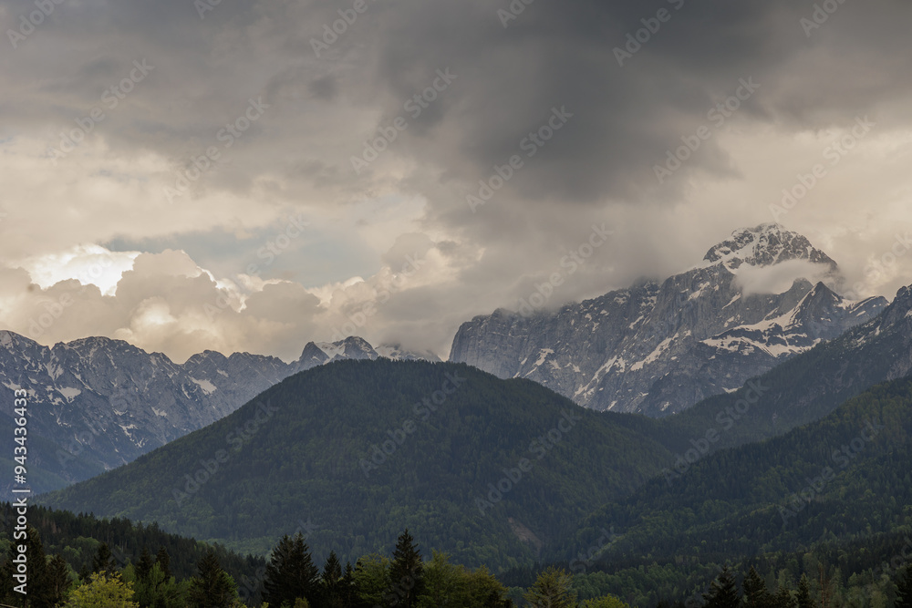 Fototapeta premium dettagli di alcune catene montuose alpine nella penombra, sotto un cielo piovoso, minaccioso e scuro, nelle montagne del nord est Italia, vicino a Tarvisio, di pomeriggio, in estate