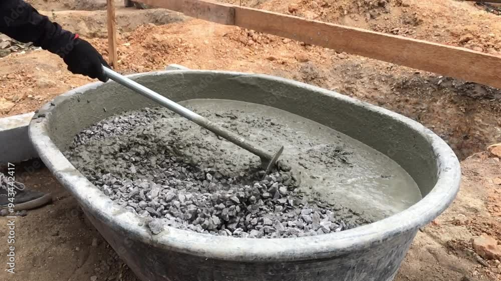 Young man is mixing concrete in the traditional way, Mixing together to make a strong concrete floor, Mixing concrete concept, Slow motion Young man is mixing concrete in the traditional way, Mixing together to make a strong concrete floor, Mixing concrete concept, Slow motion