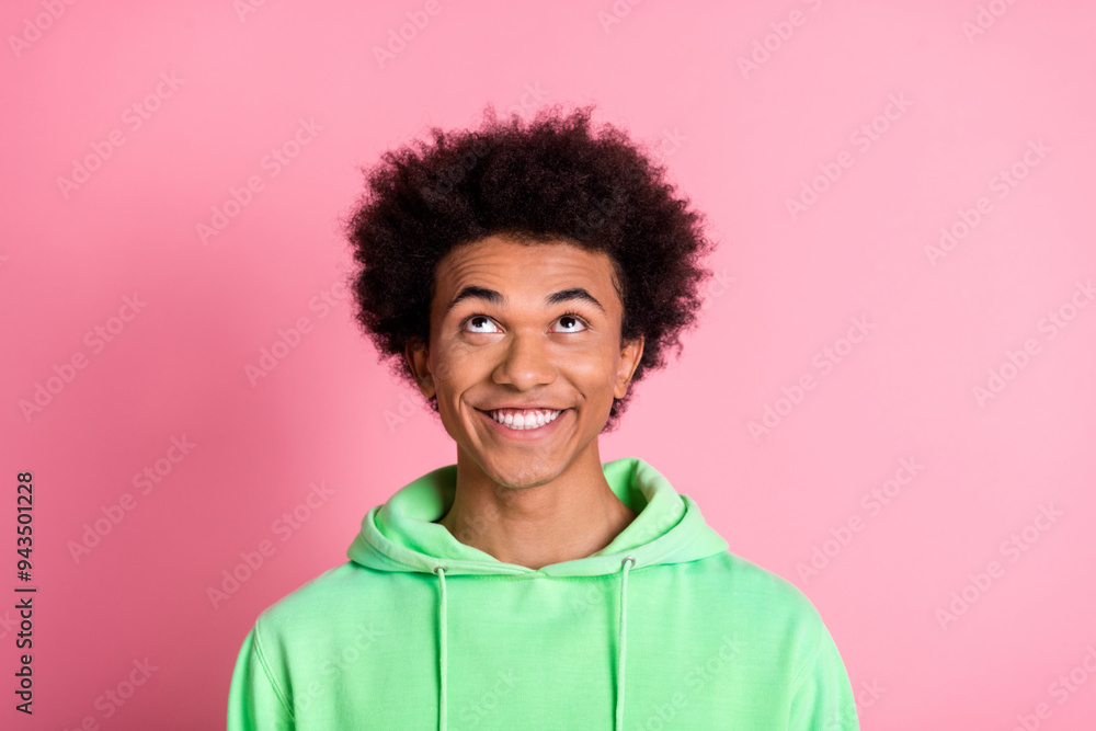Portrait of nice young man look up empty space wear green hoodie isolared on pink color background Portrait of nice young man look up empty space wear green hoodie isolared on pink color background