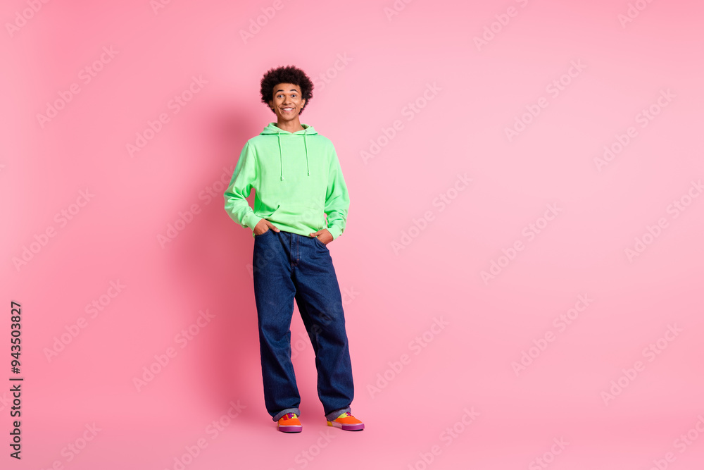 Full body portrait of cool young man posing empty space wear green hoodie isolated on pink color background Full body portrait of cool young man posing empty space wear green hoodie isolated on pink color background