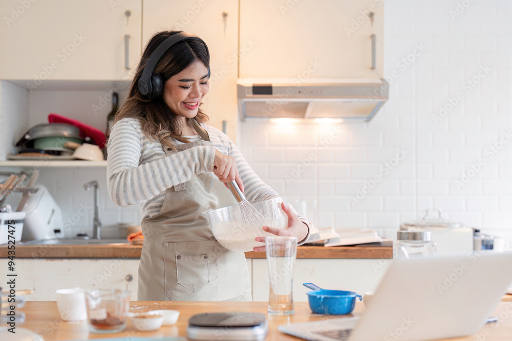 Happy Home Baker Mixing Ingredients with Laptop Nearby Happy Home Baker Mixing Ingredients with Laptop Nearby