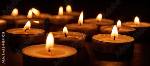 Close up shot with numerous lit candles on a black background providing ample copy space image