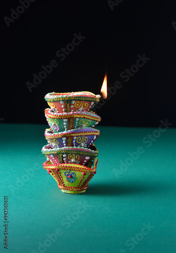 Several hand-painted Diwali lamps are stacked on each other. Indian festive object and background. photo