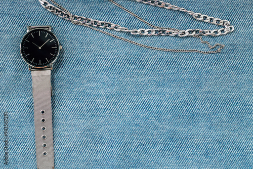 watch with jewelry on denim fabric photo