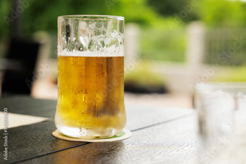 Obraz na płótnie vista in primo piano di un boccale pieno di birra chiara, appoggiato su un tavolo, di giorno, a pranzo w salonie