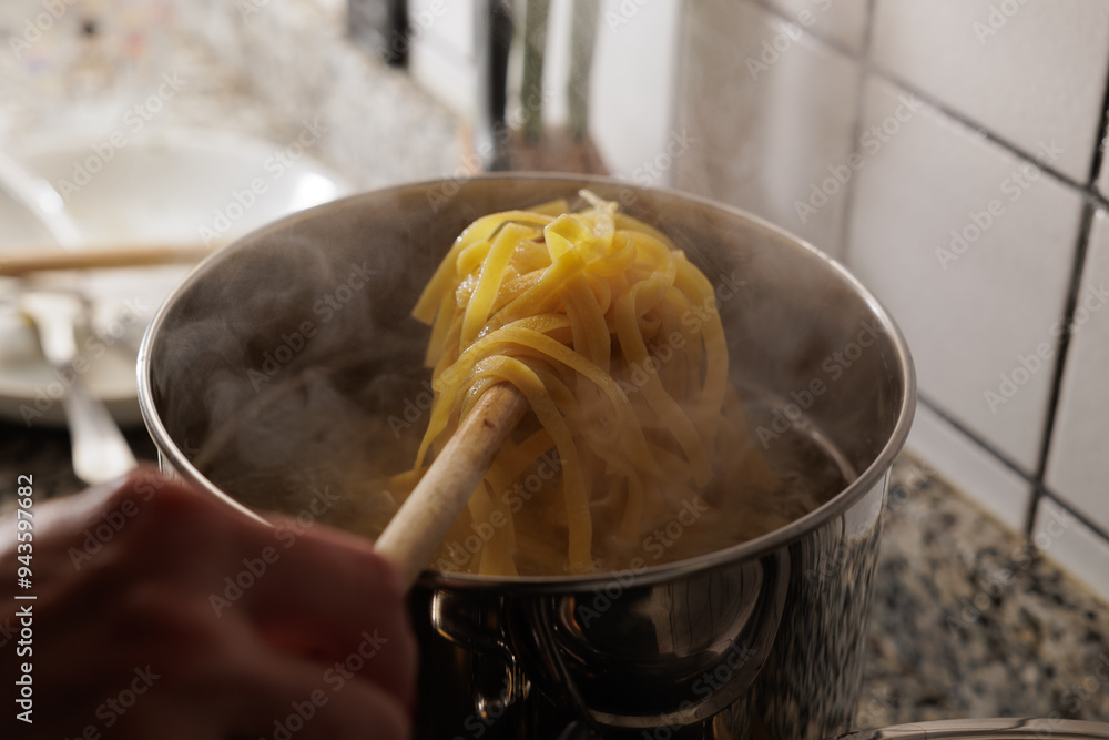 scolare la pasta dalla pentola in cucina