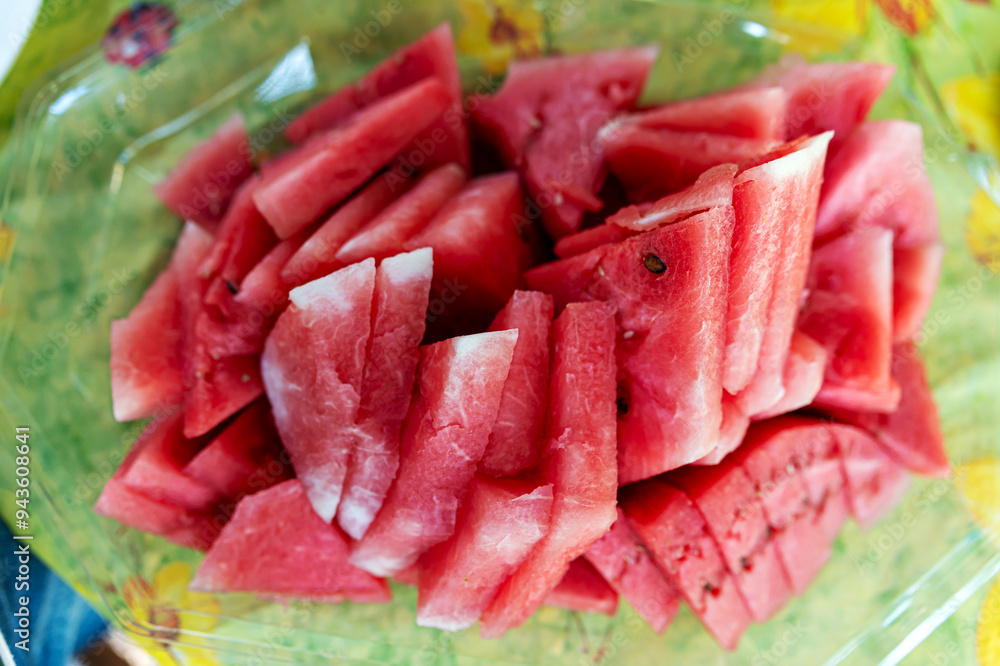 Freshly sliced watermelon arranged on a colorful plate ready for summer enjoyment at a local gathering Freshly sliced watermelon arranged on a colorful plate ready for summer enjoyment at a local gathering