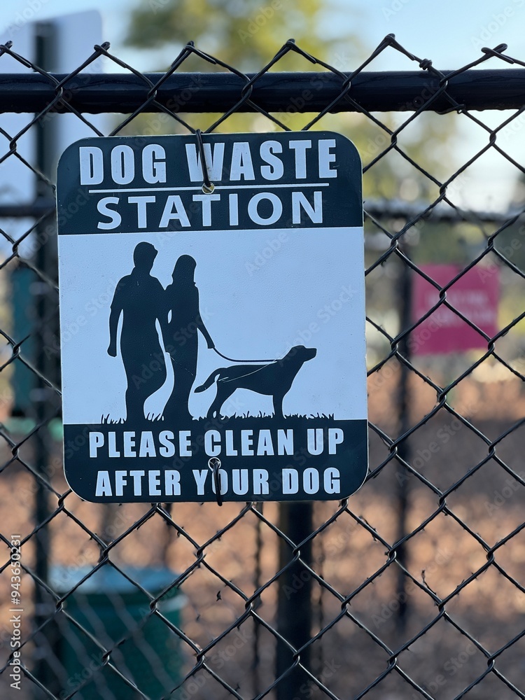 Dog Waste station sign on a fence gate with a shallow depth of field