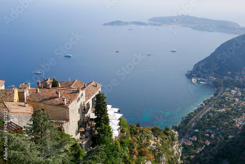 Landscape view of Eze, seen from above with gardens, roof tops on the foreground and the the mediterranean as background