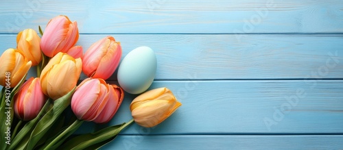 Easter eggs beside tulips o...