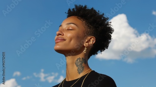 Smiling woman with short curly hair, enjoying sunny day against blue sky 