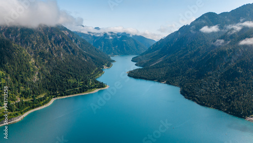 Serene reflections on Plansee Lake, nestled among the majestic Austrian Alps at sunrise